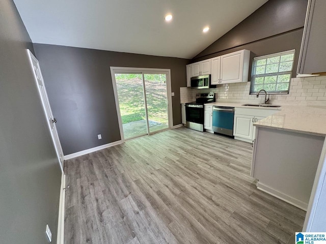 5835 Brenda Dr, Trussville, AL 35173 - kitchen featuring stainless steel appliances, a sink, light wood-type flooring, decorative backsplash, and light countertops