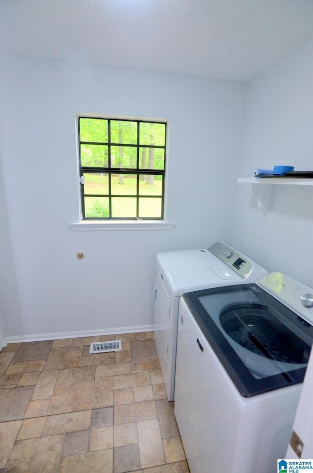 laundry area with baseboards, visible vents, laundry area, and washer and clothes dryer