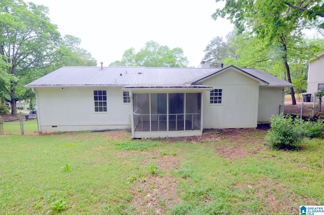 back of property with a yard, fence, metal roof, and a sunroom
