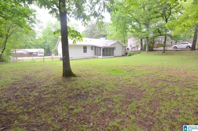 view of yard with fence and a sunroom