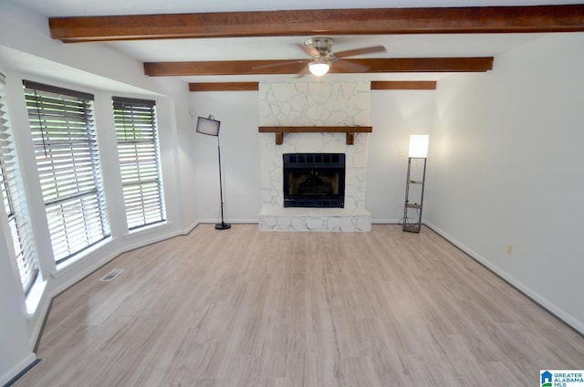 unfurnished living room featuring baseboards, a fireplace, a ceiling fan, and light wood-style flooring