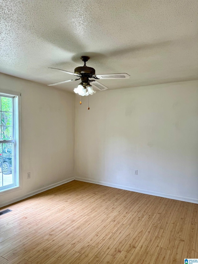 1474 Champion Rd, Oneonta, AL 35121 - spare room featuring light wood finished floors, visible vents, a ceiling fan, baseboards, and a textured ceiling