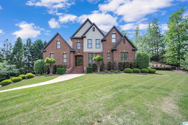 craftsman-style home with a front lawn, french doors, board and batten siding, and brick siding