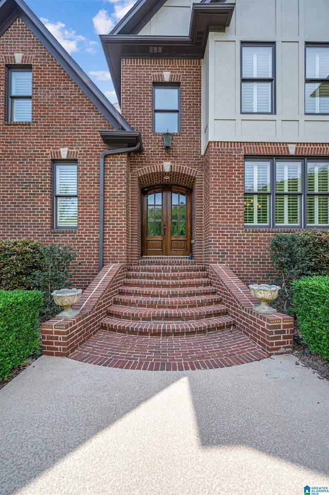 property entrance featuring brick siding and french doors