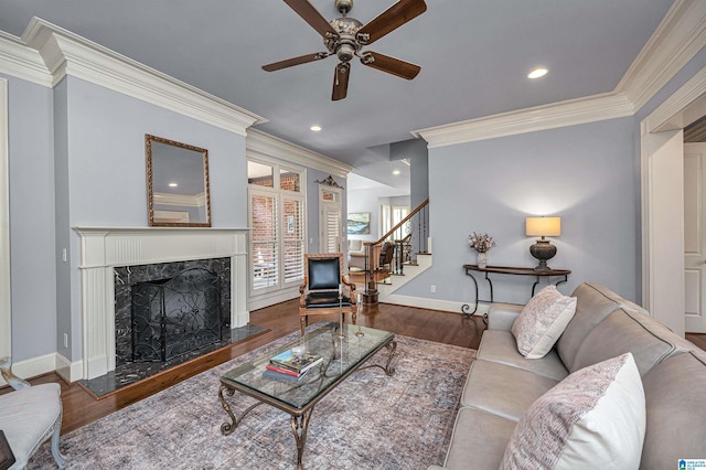 living room with stairway, ceiling fan, wood finished floors, and ornamental molding