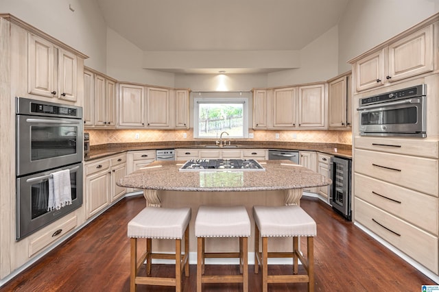 kitchen with cream cabinetry, beverage cooler, a breakfast bar, and stainless steel appliances