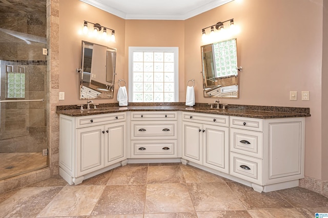 full bathroom featuring double vanity, a shower stall, ornamental molding, and a sink