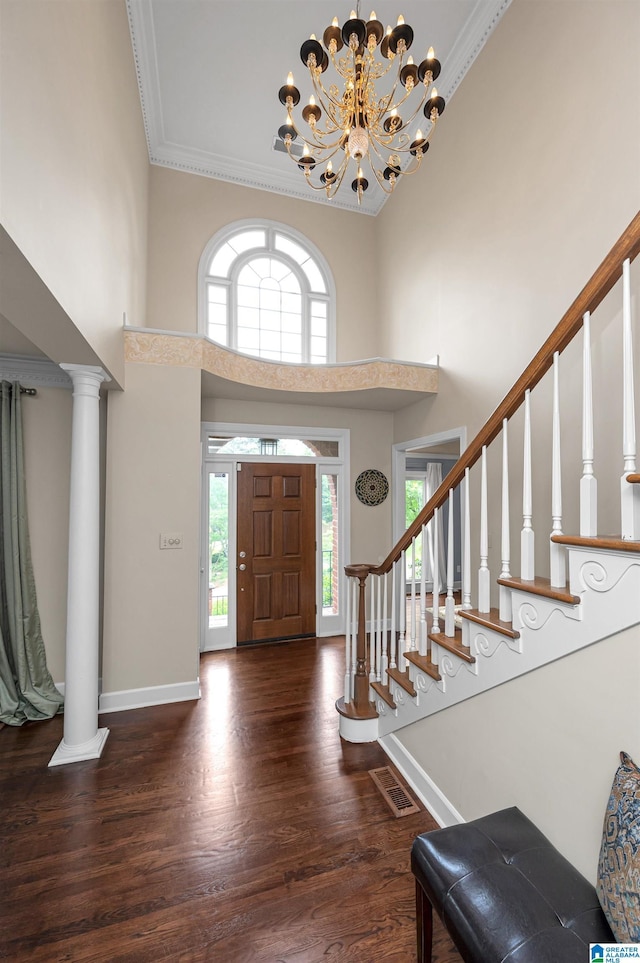 foyer featuring visible vents, wood finished floors, stairs, and a towering ceiling