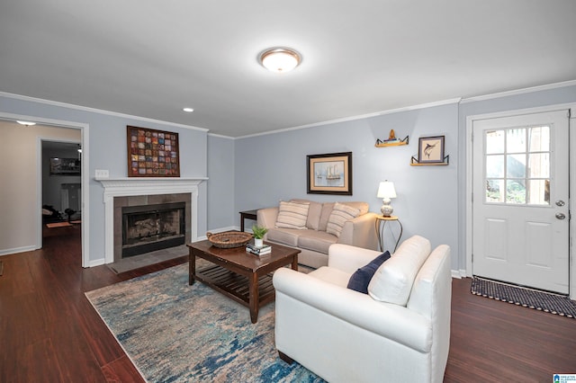 living room featuring a tile fireplace, wood finished floors, crown molding, and baseboards