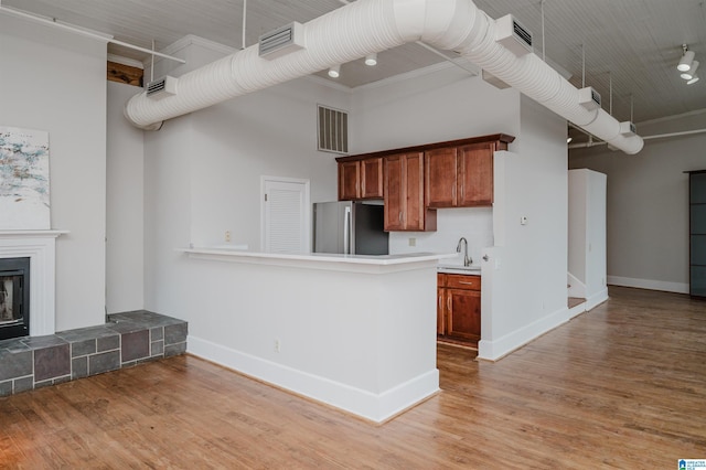 113 N 22nd St Unit 403, Birmingham, AL 35203 - kitchen with freestanding refrigerator, brown cabinets, light wood-style floors, light countertops, and a fireplace