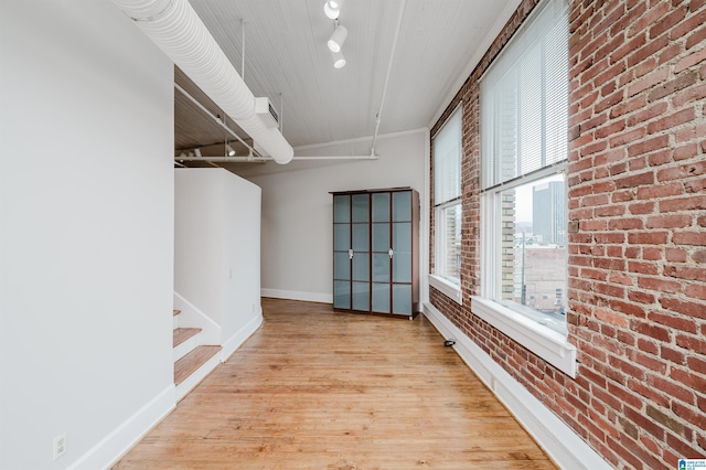113 N 22nd St Unit 403, Birmingham, AL 35203 - spare room featuring brick wall, light wood-style flooring, and rail lighting