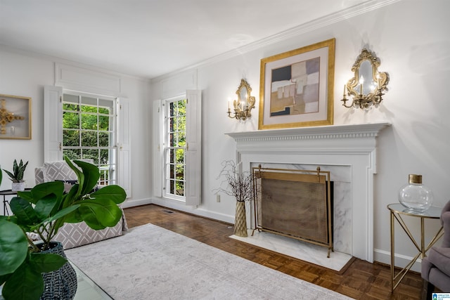 living room featuring a high end fireplace, crown molding, and baseboards