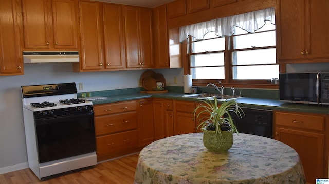 kitchen featuring range with gas cooktop, a sink, stainless steel microwave, under cabinet range hood, and black dishwasher