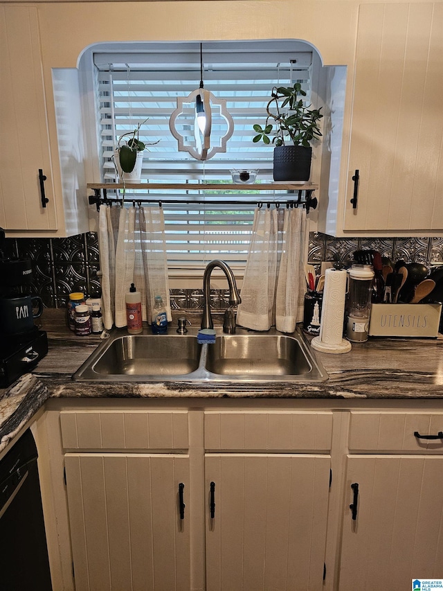 kitchen featuring white cabinets, dishwasher, decorative backsplash, and a sink