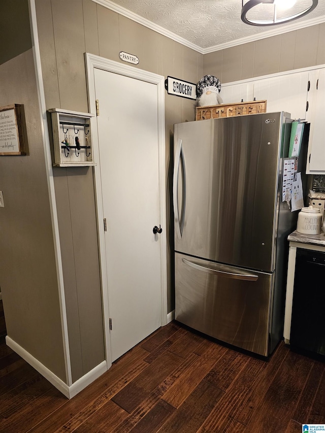 kitchen featuring white cabinets, a textured ceiling, freestanding refrigerator, crown molding, and dark wood-type flooring