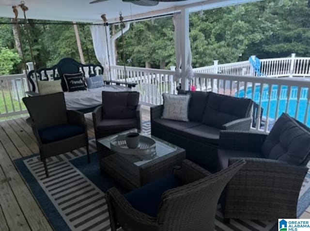 wooden terrace featuring a fenced in pool, outdoor dining area, ceiling fan, and an outdoor living space