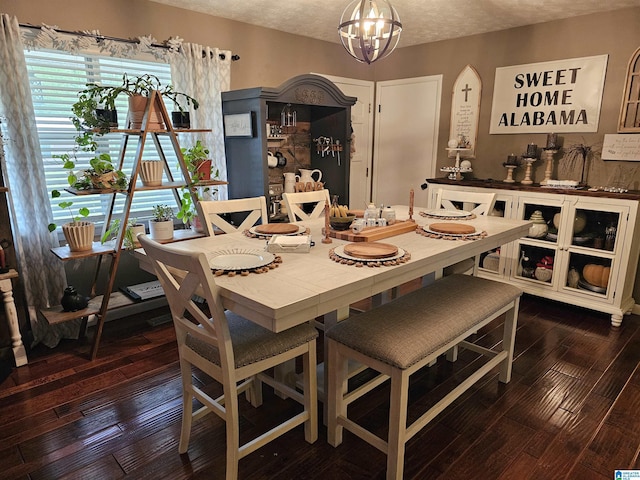 dining room featuring a textured ceiling, a notable chandelier, and wood-type flooring