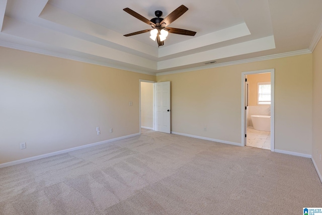 spare room with a raised ceiling, a ceiling fan, baseboards, and light carpet