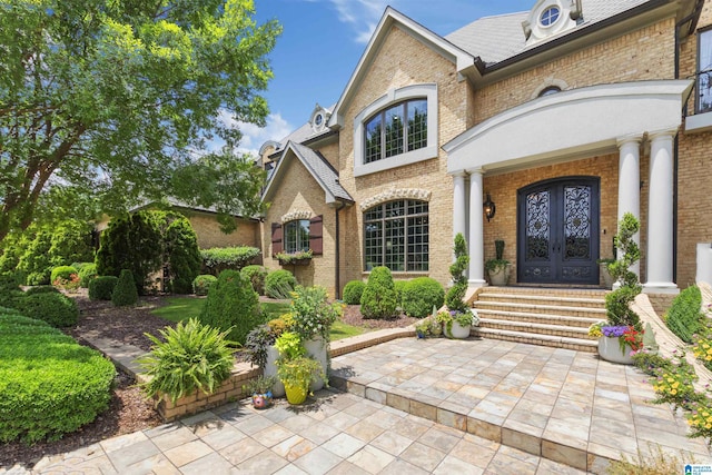 entrance to property featuring brick siding and french doors