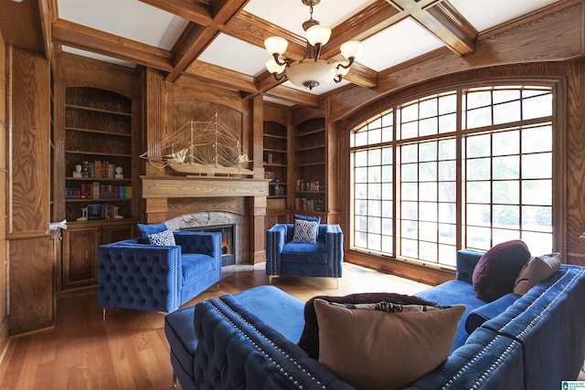 living room featuring wood walls, built in features, beam ceiling, and plenty of natural light