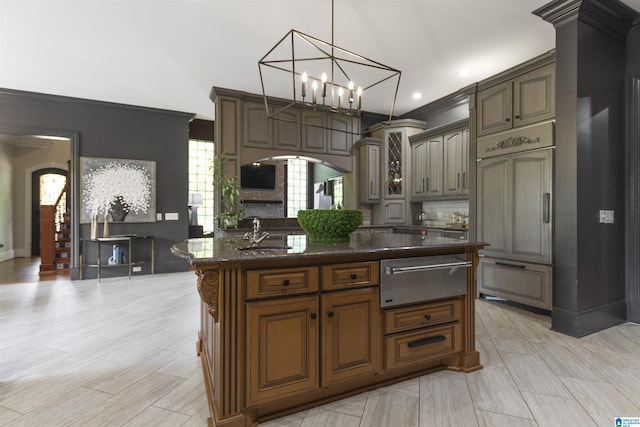 kitchen featuring a warming drawer, arched walkways, ornamental molding, and a sink