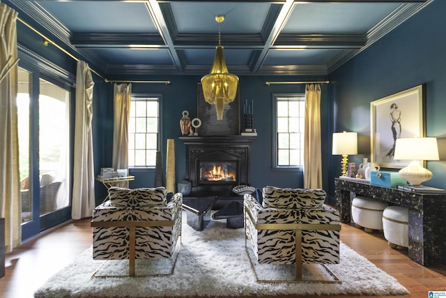 living area with a glass covered fireplace, wood finished floors, a wealth of natural light, and beam ceiling
