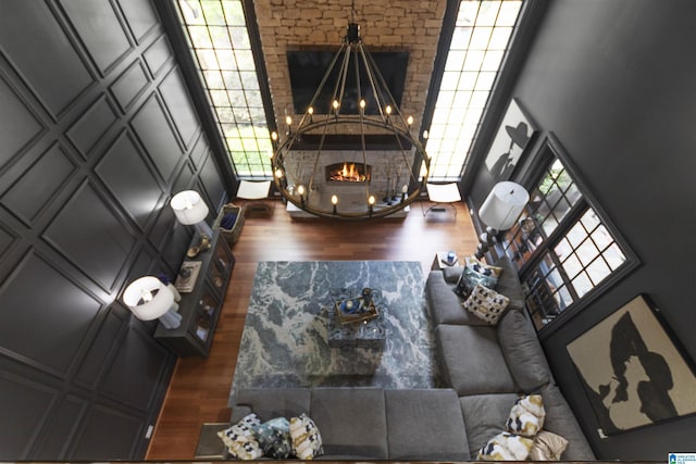 living area featuring a chandelier, plenty of natural light, a high ceiling, and dark wood-style flooring