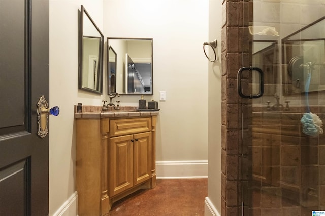 full bath featuring baseboards, vanity, and a stall shower