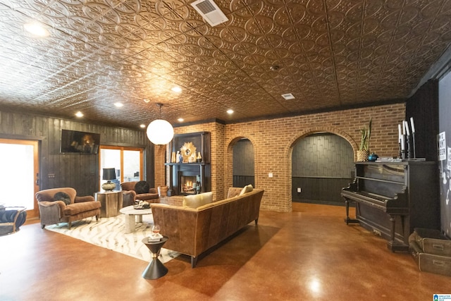 living room with arched walkways, concrete floors, an ornate ceiling, and visible vents