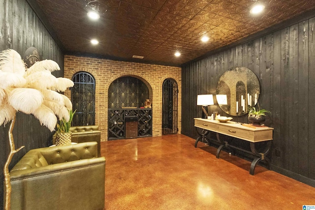 wine room featuring concrete floors, an ornate ceiling, wooden walls, and recessed lighting