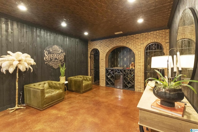 wine room featuring brick wall, concrete floors, and recessed lighting