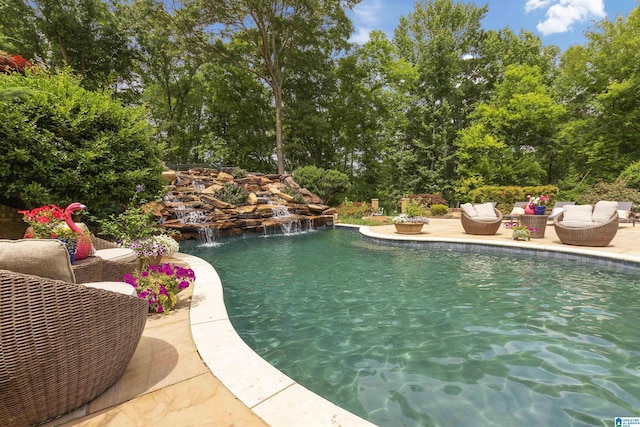 outdoor pool with an outdoor living space and a patio area