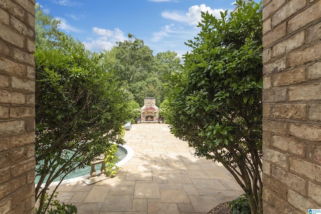 view of patio with an outdoor stone fireplace