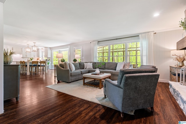 living room with dark wood-style floors and an inviting chandelier