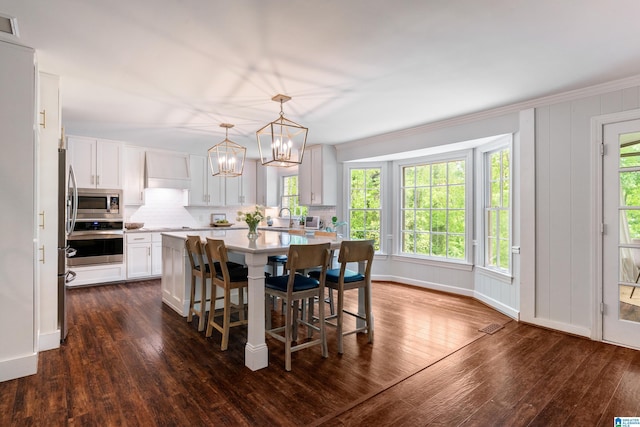 dining space with dark wood-style floors, a wealth of natural light, and a chandelier