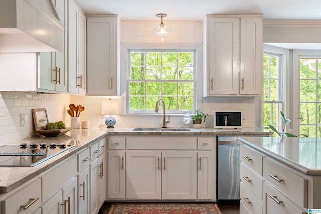 kitchen featuring tasteful backsplash, black electric stovetop, white cabinets, and a sink