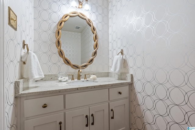 bathroom with vanity and wallpapered walls