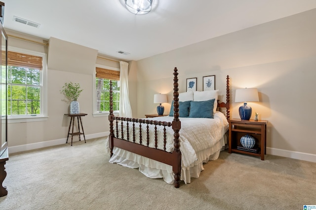 carpeted bedroom with visible vents, baseboards, and multiple windows
