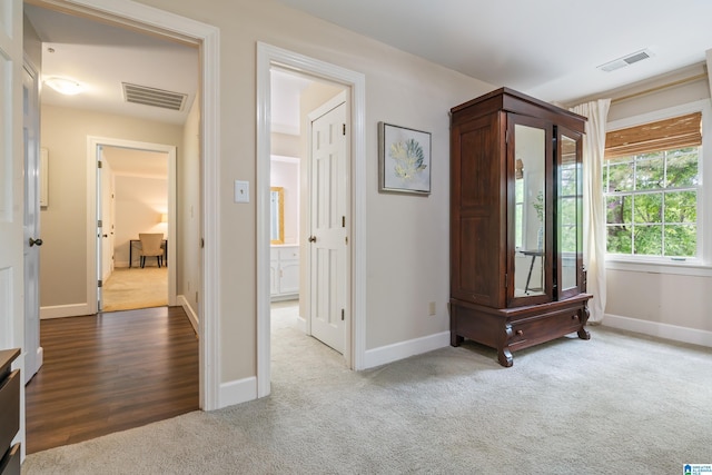 corridor with carpet flooring, baseboards, and visible vents