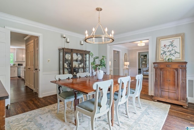 dining room featuring visible vents, a chandelier, a wainscoted wall, dark wood-style flooring, and ornamental molding