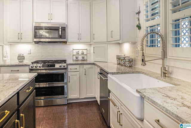 kitchen featuring a sink, white cabinets, appliances with stainless steel finishes, and decorative backsplash