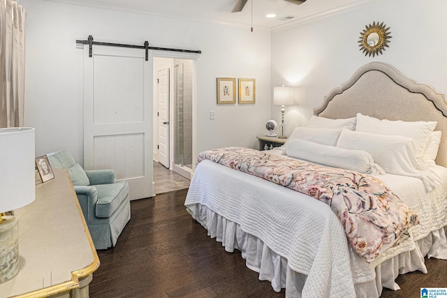 bedroom featuring a barn door, a ceiling fan, visible vents, ornamental molding, and wood finished floors