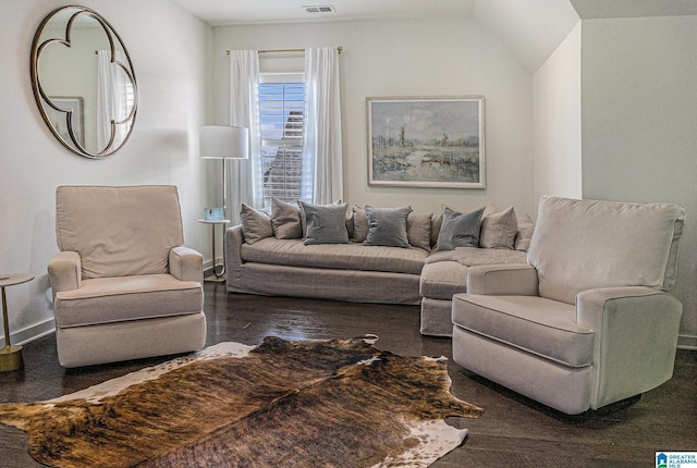 living room with visible vents, vaulted ceiling, and wood finished floors