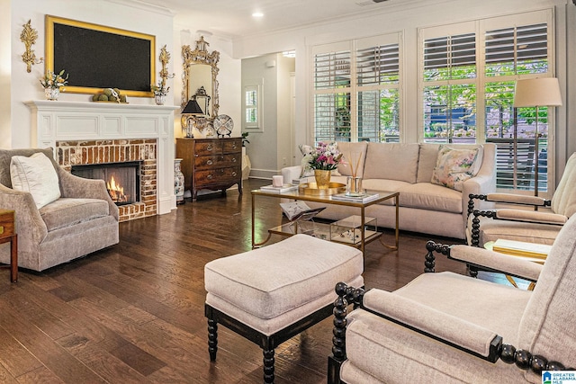 living room with hardwood / wood-style flooring, crown molding, baseboards, and a brick fireplace