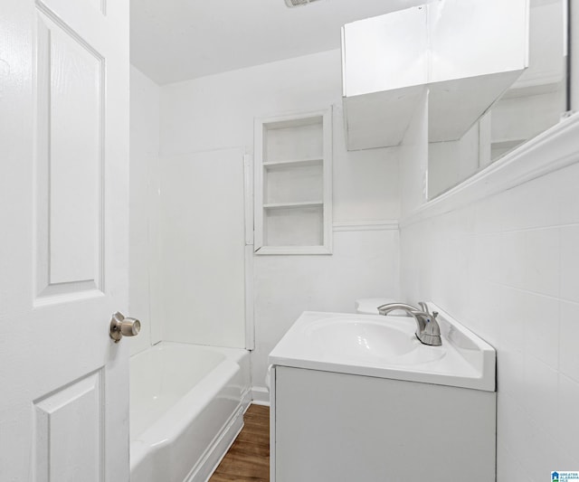bathroom featuring vanity,  shower combination, and wood finished floors
