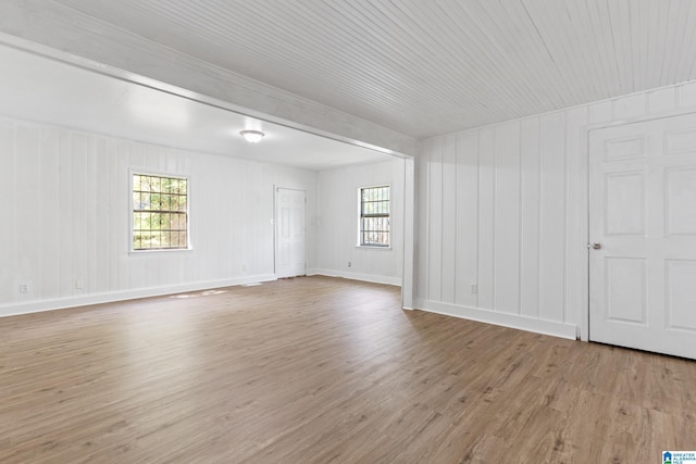spare room with baseboards and wood finished floors
