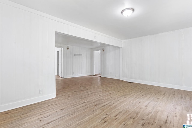 empty room with baseboards, visible vents, and wood finished floors