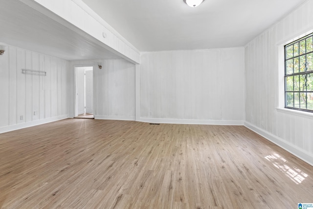 spare room featuring baseboards and wood finished floors