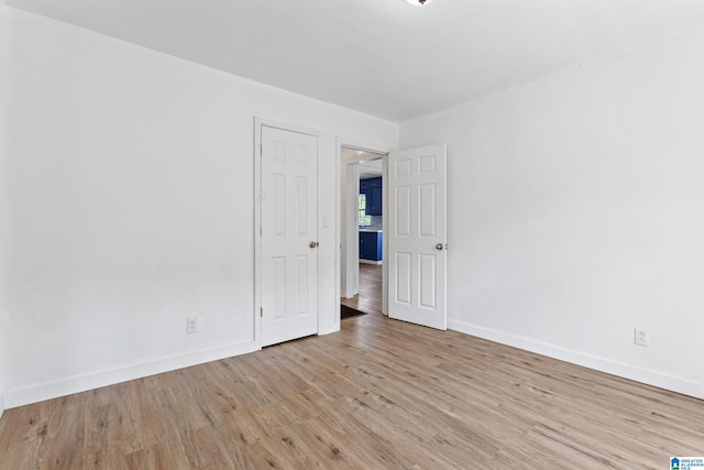 unfurnished room with baseboards and wood finished floors