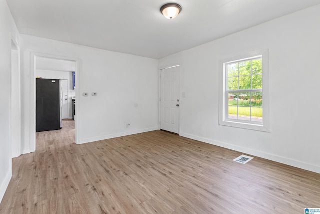 unfurnished room with baseboards, light wood-style flooring, and visible vents